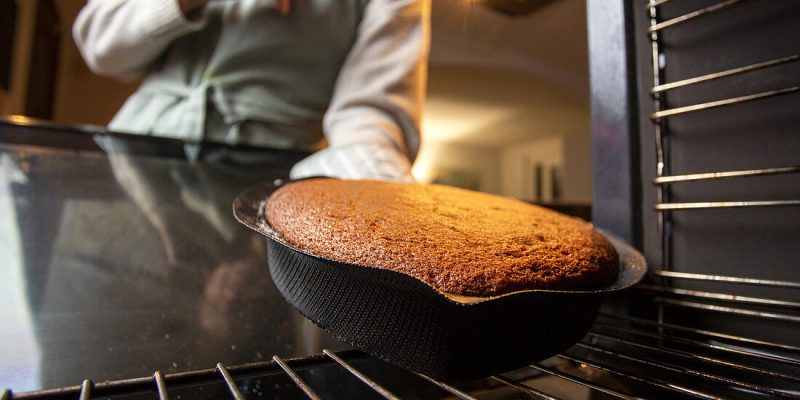 Taking a baked cake out of the oven